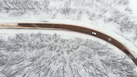 DRONE, TOP DOWN: Car drives through a slippery snow covered intersection. Flying Stock Footage 123819290