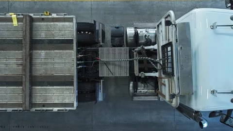 Drone top down descends to connection point of semi truck tractor to flat Stock Footage 270207574