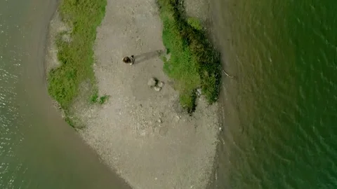 Drone top-down of emerald lake with sandy islet Stock Footage 327866785