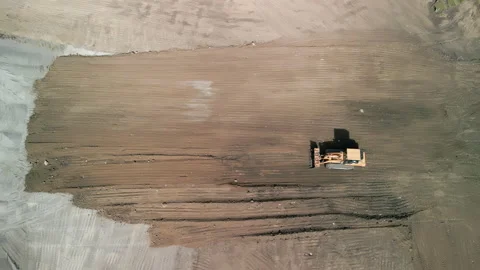 Drone top down footage. A bulldozer levels a plot of land for development. Top Stock Footage 224530686