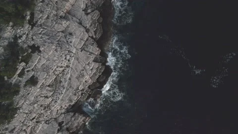 Drone top down moving higher over rock beach and waves, Mljet, Croatia Video stock 205385856