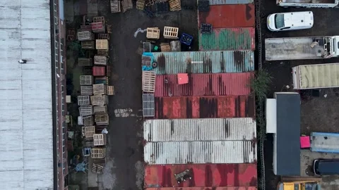 Drone top-down reverse over colorful shipping containers by warehouse roof and Stock Footage 331461776