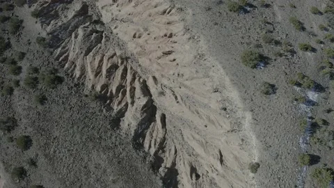 Drone top down shot of a dusty desert landscape with spotted snow patches Stock Footage 167672921