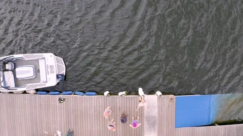 Drone top down shot of swimmers jumping into the water Stock Footage 132905546