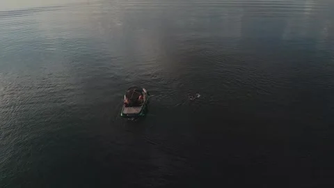 Drone top-down tracking shot of a wakeboard boat on Lake Paranoa at sunset Stock-Footage 342661262