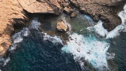 Drone Top Down View of Ocean Waves Crashing on Rocky Shore Peaceful Coastal 動画素材 342580984