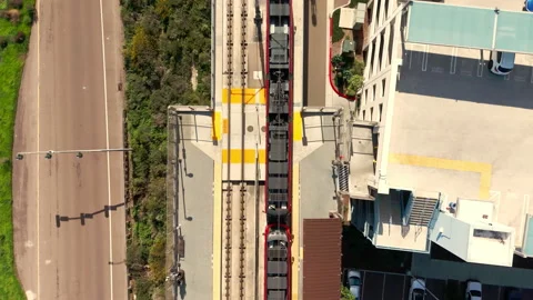 Drone top down view of red commuter train moving along rail tracks Stock Footage 330517410