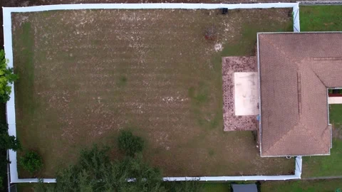 Drone top down view of a residential backyard with white fencing Stock Footage 258862982