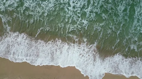 Drone top-down view of turquoise waves on a sandy beach in Hawaii 動画素材 347825967