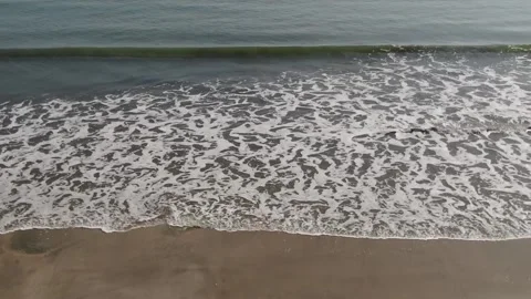 Drone top shot of a single wave crashing to shore Stock Footage 295103923