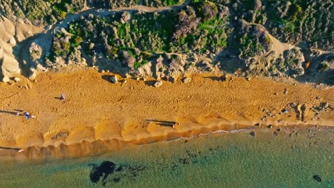 Drone top sunset view of sand beach, people, green hills. Malta island Stock Footage 323571794