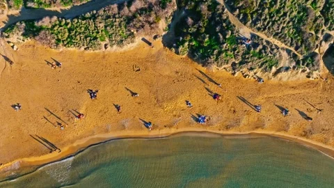 Drone top sunset view of sand beach, people, green hills. Maltese island Stock Footage 323571810