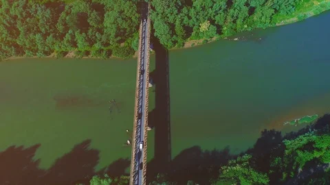 Drone top view of busy traffic bridge over quite green river, in the sunny and Stock Footage 110307805
