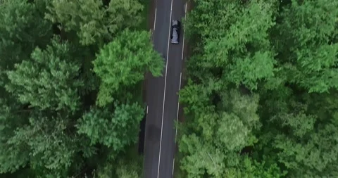 Drone top view camera tracking black car driving very fast on empty highway Stock Footage 139243937