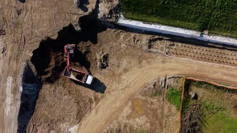 Drone top view of excavator loading soil into truck, creating dynamic patterns 動画素材 332791588