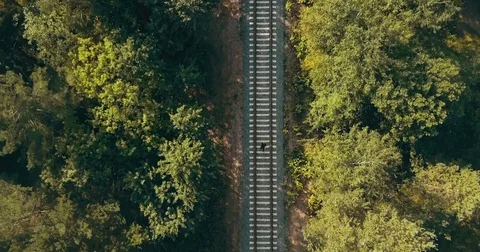 Drone top view of man running on train track. Escaping from past problems Stock Footage 83257020