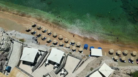Drone top  view: a sandy beach with parasol next to a restaurant terrace, Stock Footage 214393237