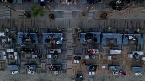 Drone top view: a sandy beach with parasol next to a restaurant terrace, shore Stock Footage 236722898