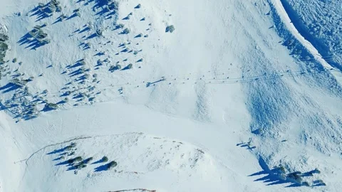 Drone top view of ski lift and trail cutting through snowy alpine terrain Stock Footage 319658439