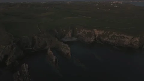 Drone tracking across coast line holyhead wales revealing sunset over ocean Stock Footage 277623172