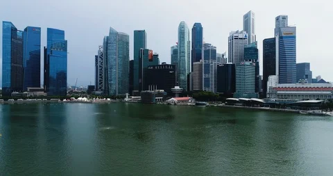 Drone tracking in across Marina Bay toward Singapore skyscrapers. Stock Footage 87262499