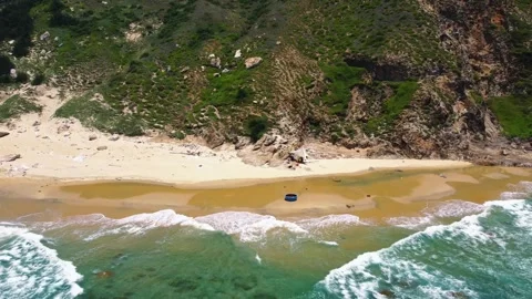 Drone tracking along a wild beach below green mountains 4K Stock Footage 340068572