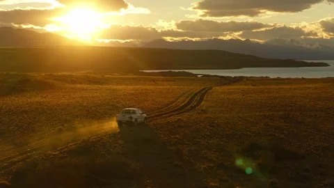 Drone tracking ascent above off road vehicle in Patagonian steppe at sunset 库存影片 336609756