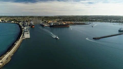Drone tracking in to busy Australian port as two tugboats head to sea. Stock Footage 88451994