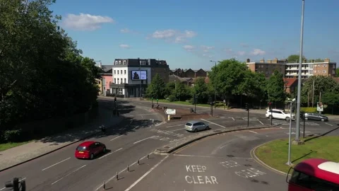 Drone tracking car leaving roundabout, double decker waiting inside crossroad Vídeos de archivo 155520175
