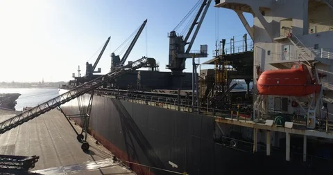 Drone tracking down beside large freighter at sunset in Australian port. Stock Footage 86851926
