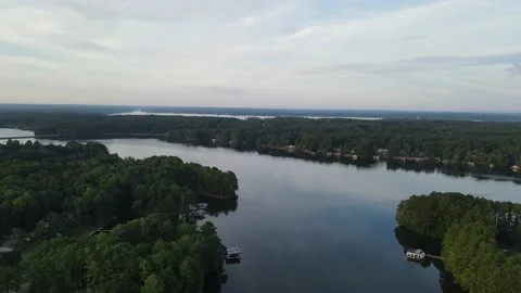 Drone tracking down a creek off of a large lake Stock Footage 209696119