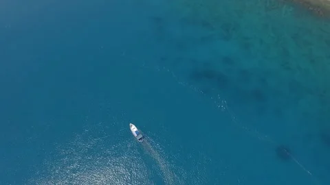 A drone is tracking a fisherman while he’s fishing from his boat Stockbeeldmateriaal 309980668