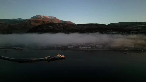 Drone tracking Fort William waterfront at dusk with winter sunset glow Stock Footage 330591581