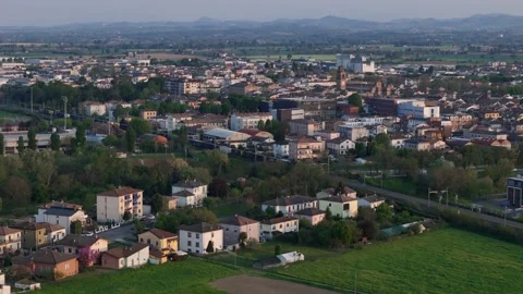 Drone tracking freight train revealing Fiorenzuola dArda skyline and Apennines Stock Footage 340155701