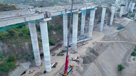 Drone tracking heavy machinery and labor on concrete overpass site. Stock-Footage 335644040