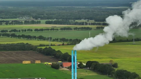 Drone Tracking Intercity Train Crossing Countryside Near Industrial Smokestack Video stock 345869399