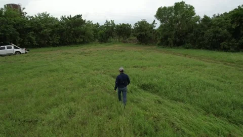 Drone tracking of men working in open field Stock Footage 234956807