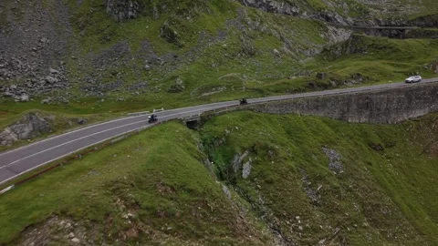 Drone tracking motorcyclists riding along the Transfăgărășan mountain road Stock Footage 340824004