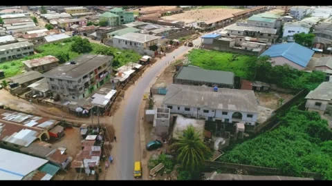 Drone tracking moving vehicle on a paved road in low income african town 库存影片 296719028