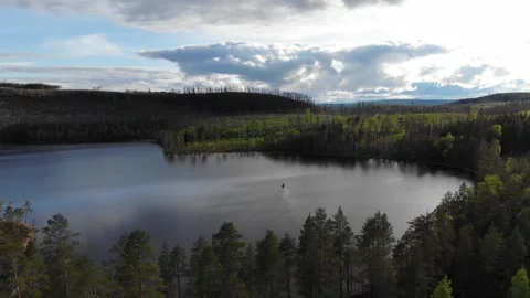Drone tracking in over lake to small boat drifting on the water Stock Footage 318195425