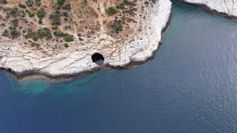 Drone Tracking Past Cave in White Coastal Cliff Stockbeeldmateriaal 340508090