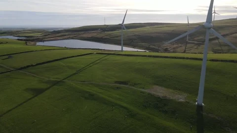 Drone Tracking Past Wind Turbines and Reservoir at Golden Hour Stock Footage 339101023