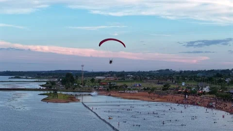 Drone tracking powered paraglider over Balneario Costa Sur beach and Paraná Stock Footage 328272117