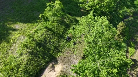 Drone Tracking Remote Controlled Mower on Grassy Slope Stock Footage 336562583