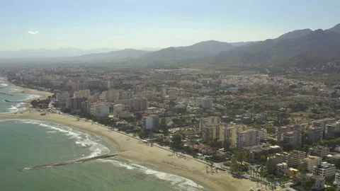 Drone tracking in from the sea flying over seafront apartments inland 스톡 동영상 150406908