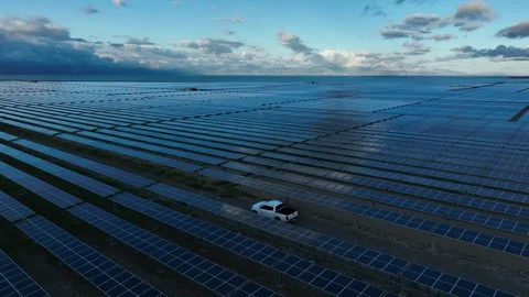Drone tracking shot along solar panel rows near fenced area Stock Footage 324542049