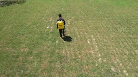 Drone tracking shot from behind of farmer spraying pesticide 스톡 동영상 334116794