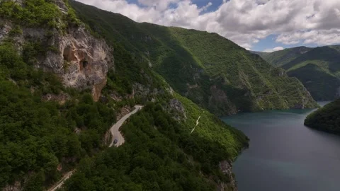 Drone Tracking Shot of Car Driving Down Dangerous Mountain Cliff Road, 4K Vídeos de archivo 337180069