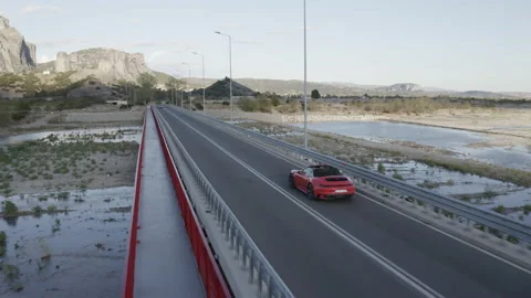 Drone tracking shot close to a red porsche over bridge in Greece. Video stock 147329377