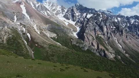Drone tracking shot left over alpine plateau and jagged peaks in Kazakhstan Видео 337127873